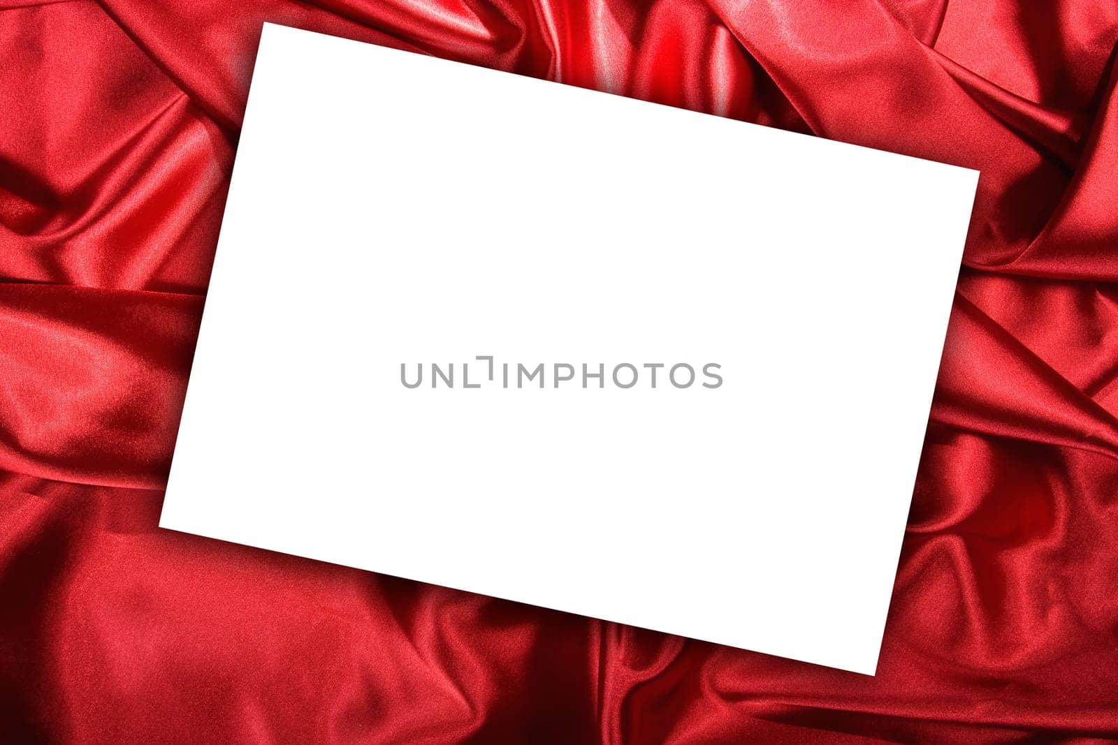 Blank white card on red colored satin