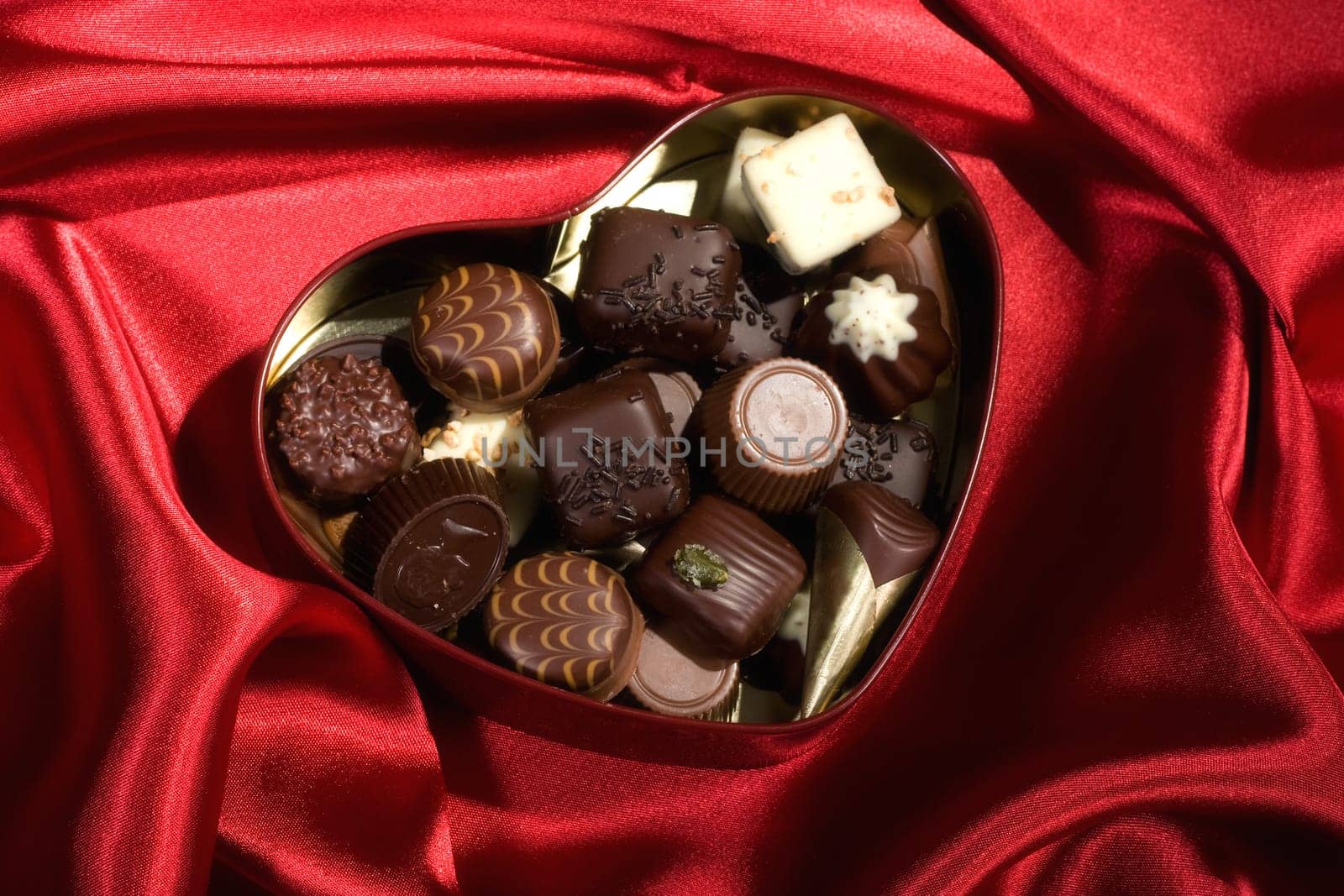 Heart Shaped Box of Candy on red satin