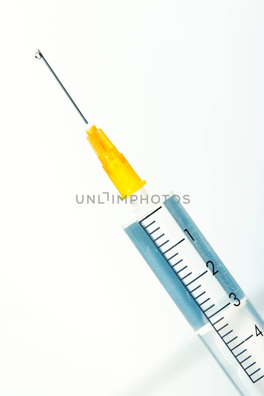 Drop of a liquid on a needle of syringe