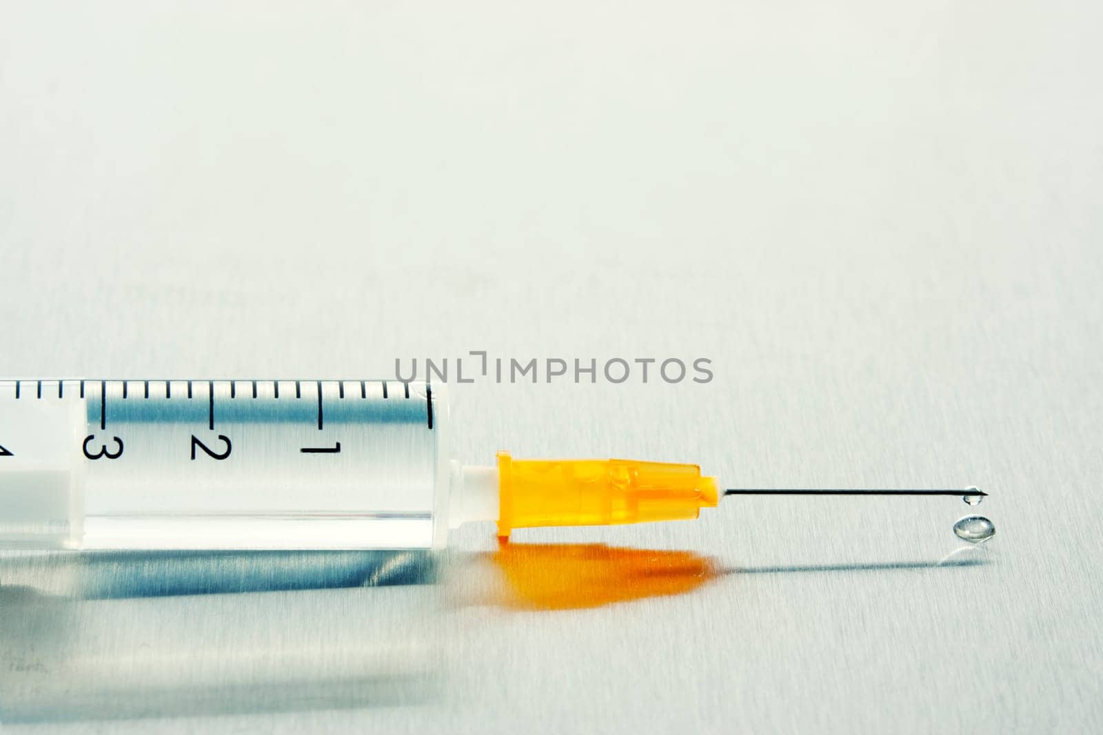 Drop of a liquid on a needle of syringe