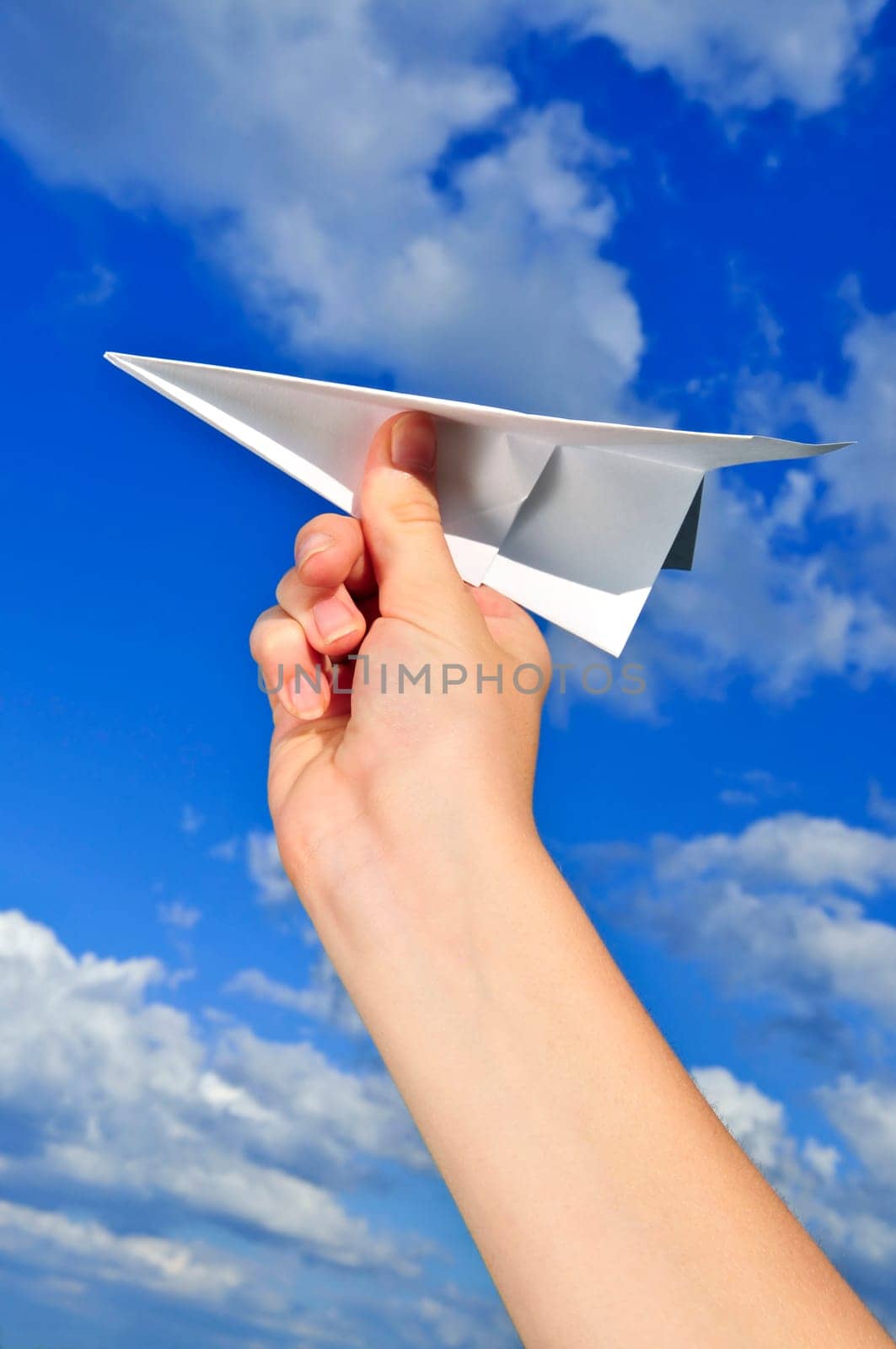 Hand holding paper airplane