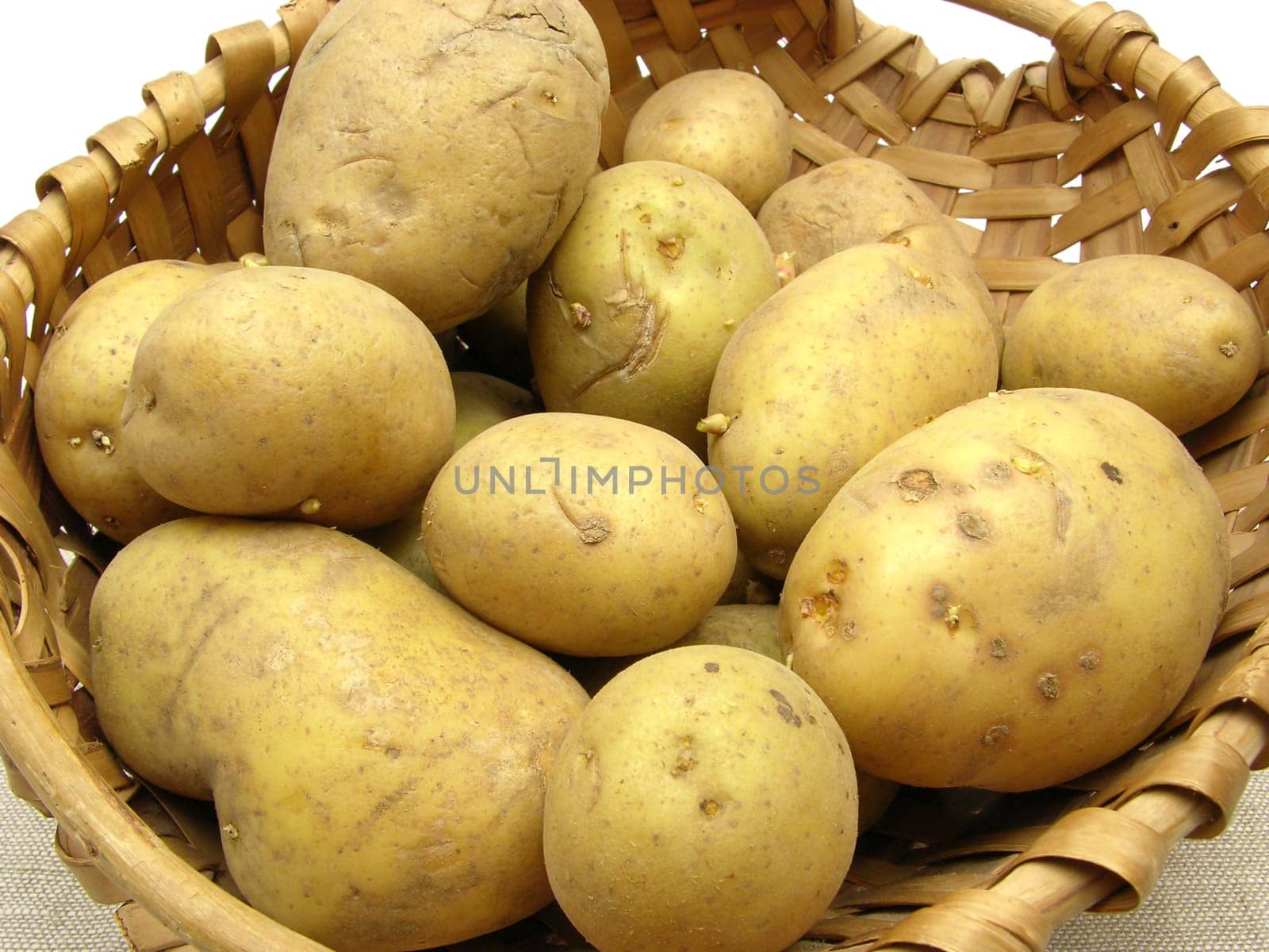 Basket of potatoes on beige blanket