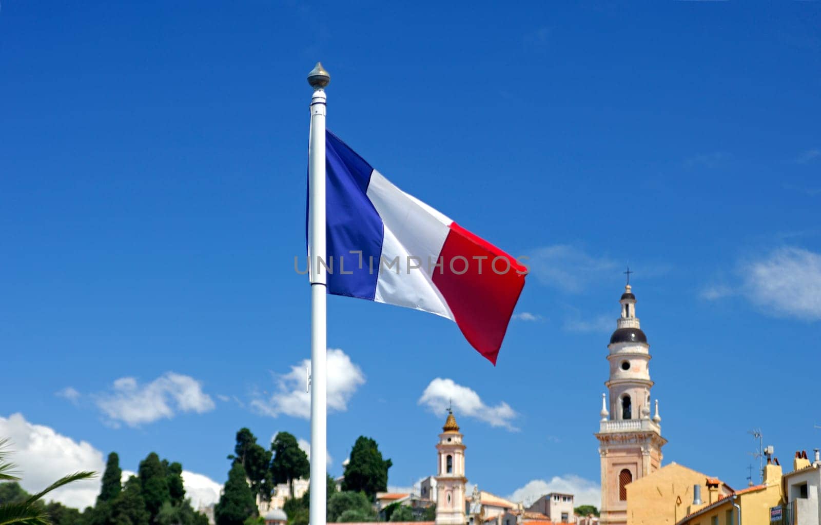 The tricolor,the French national flag,in front of a small-town backdrop,Men