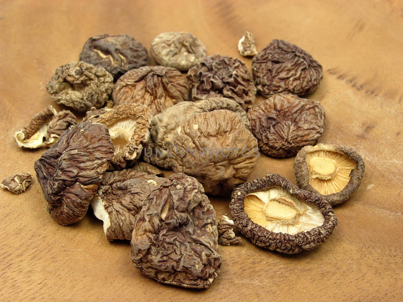 Dried shiitake mushrooms arranged on brown wooden board