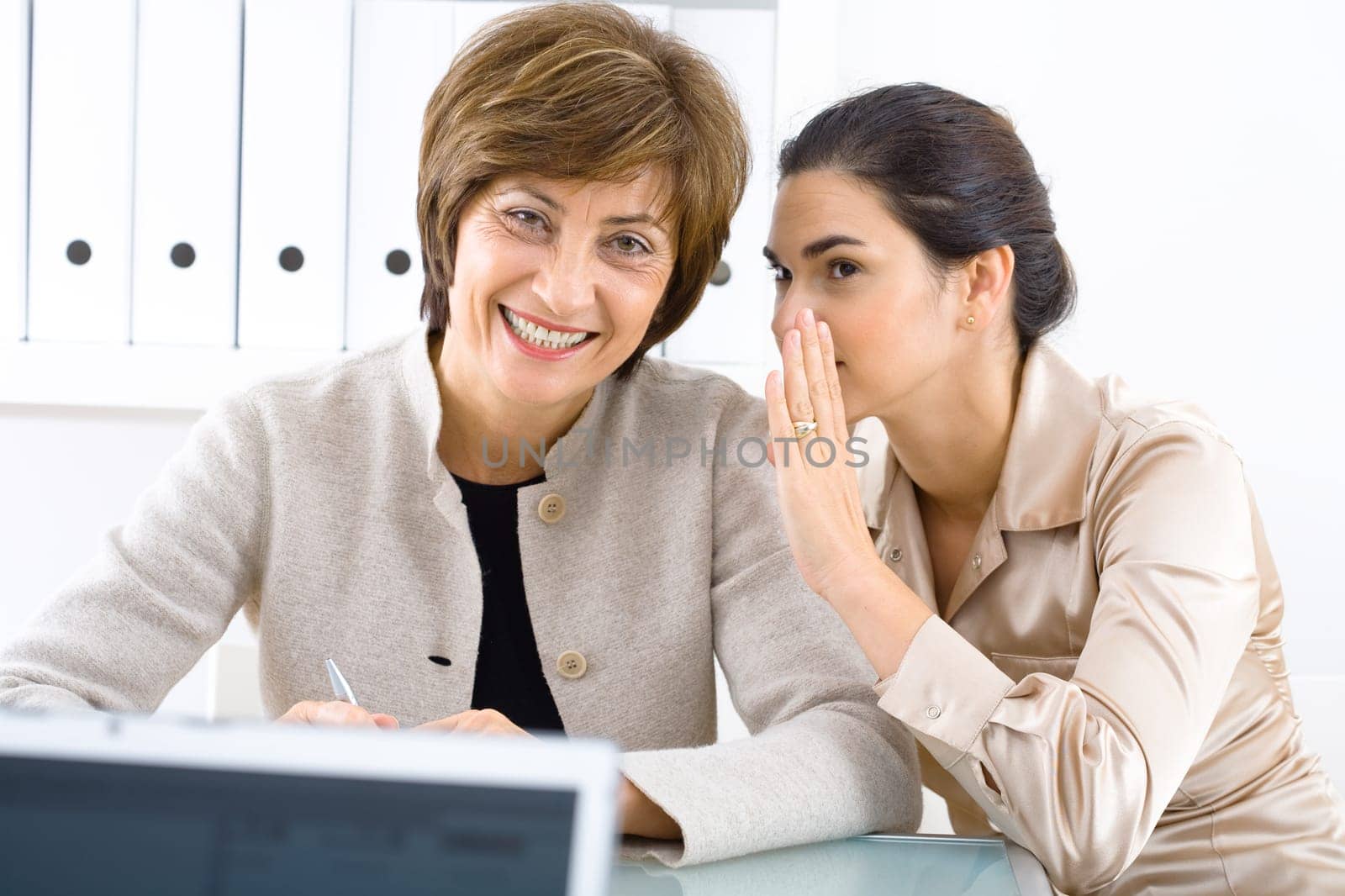 Whispering businesswomen