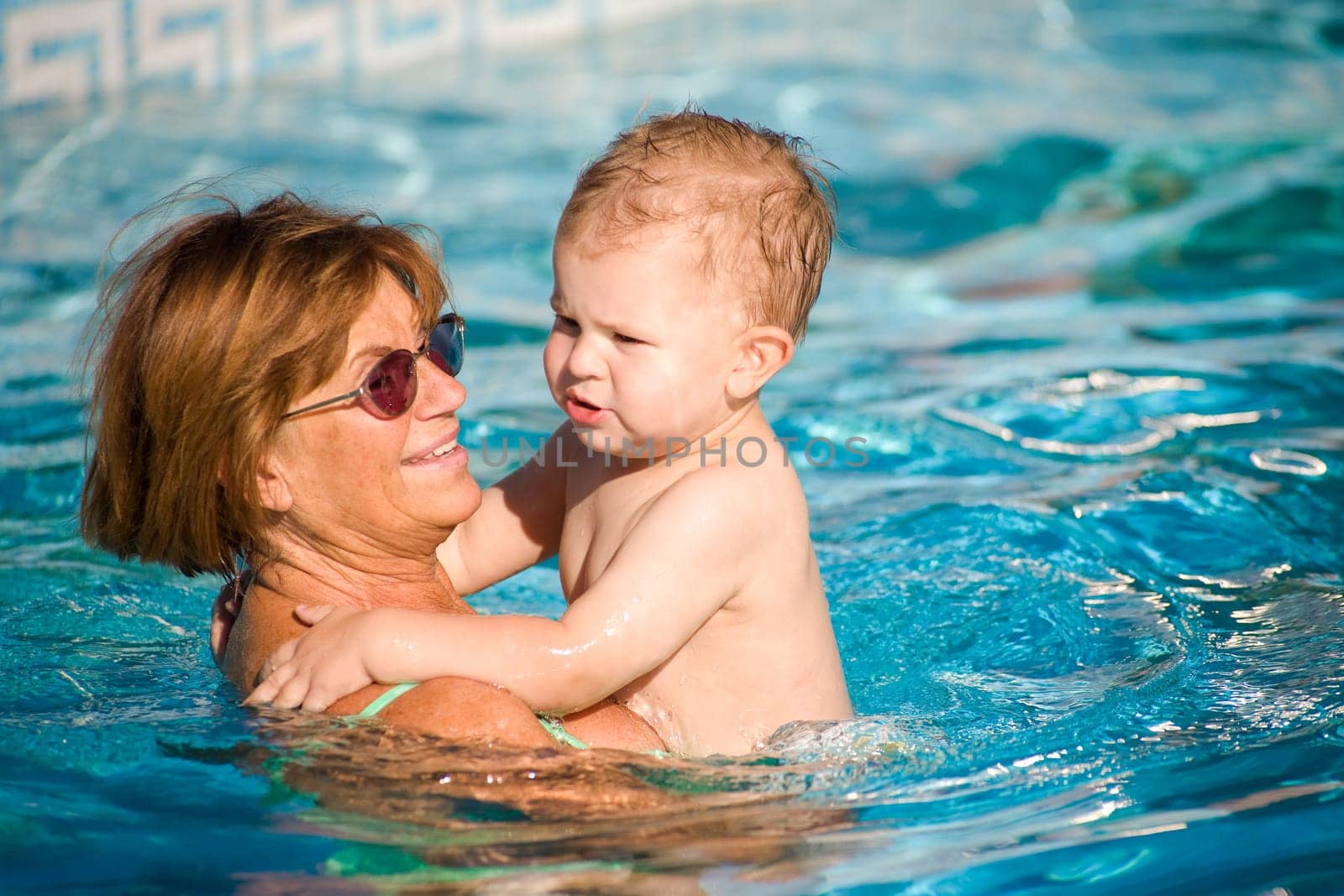 Grandmother swimming with grandson