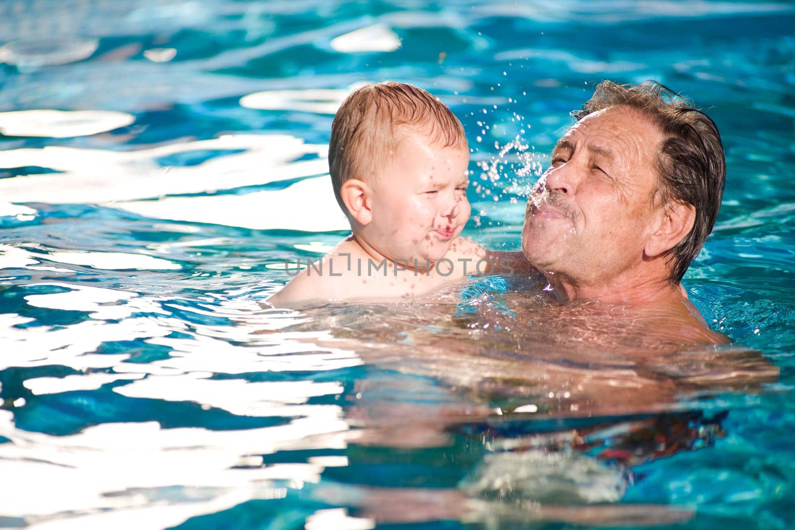 Grandfather swimming with grandson