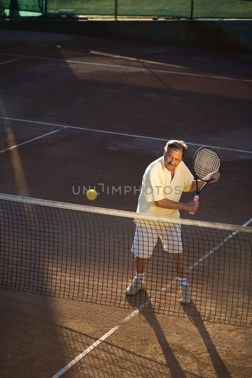 Senior man playing tennis
