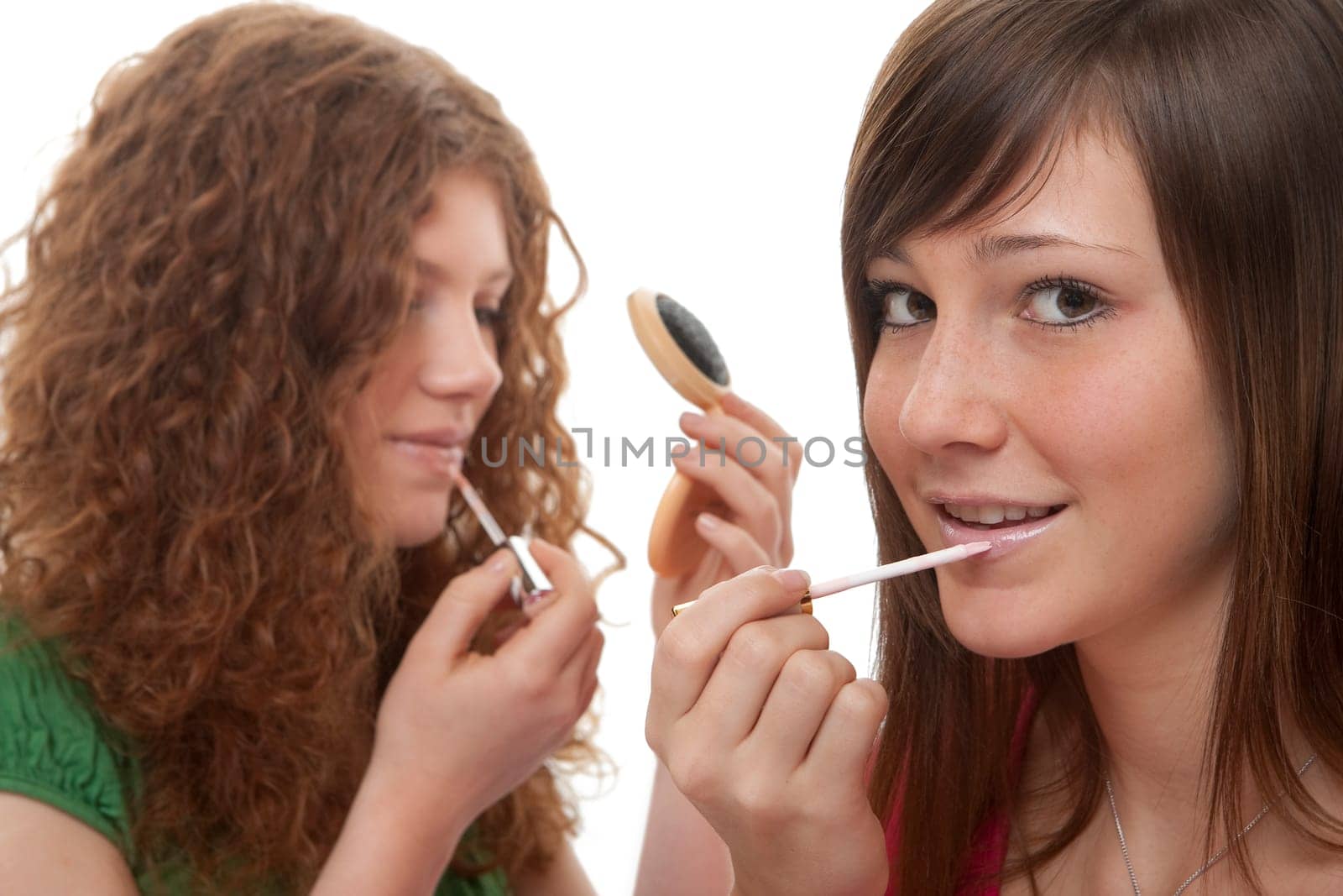 Female teens putting on make-up