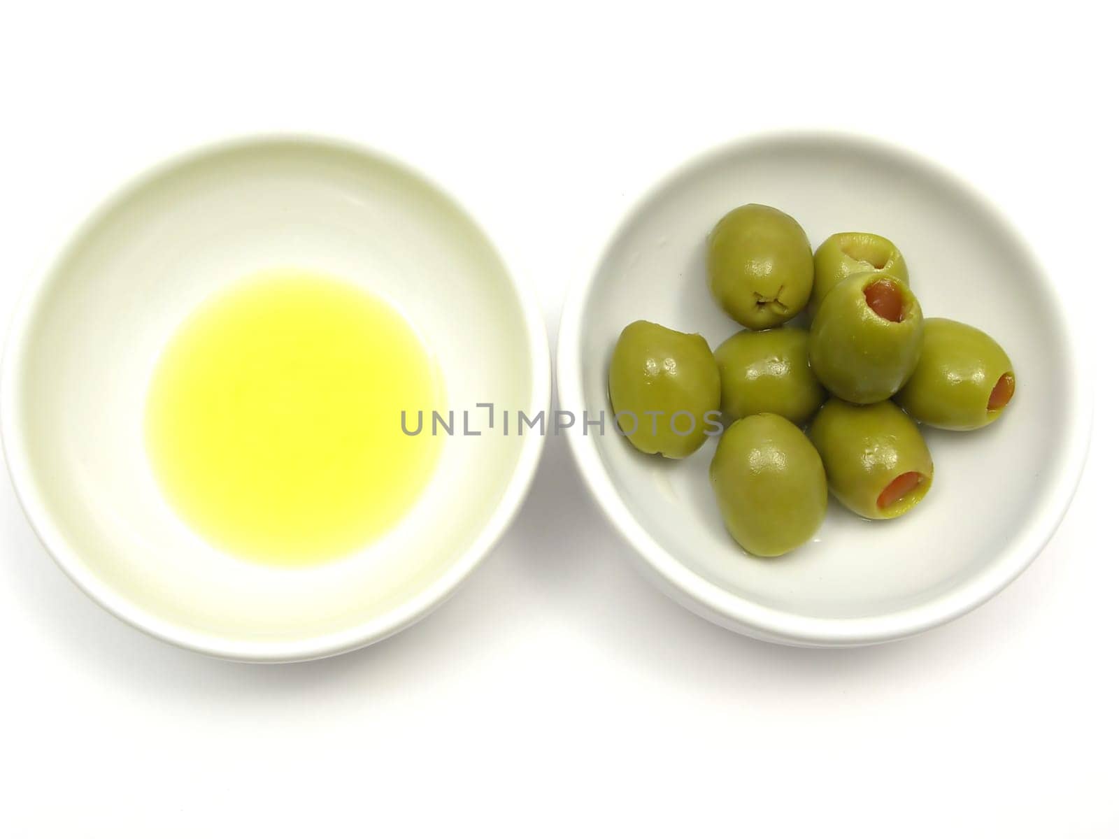 Two porcelain bowls with olive oil and olives