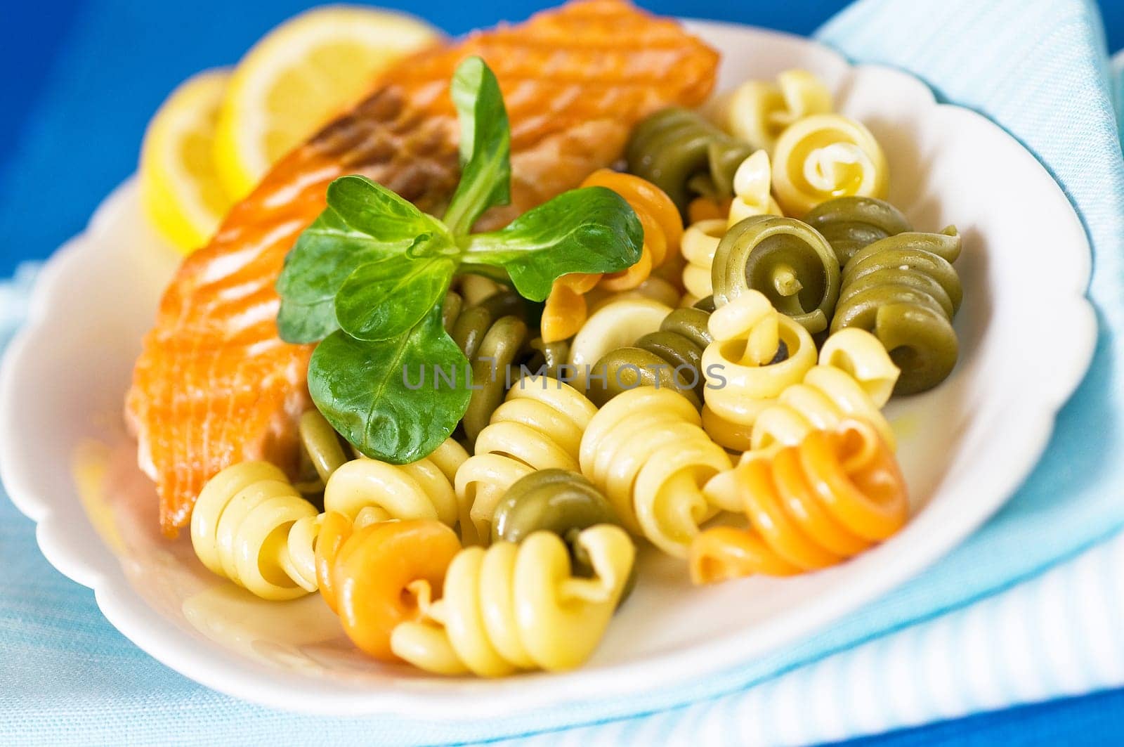 Salmon fillet with noodles served on plate