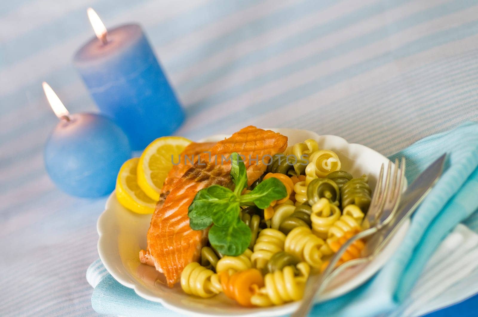 Salmon fillet with noodles served on plate