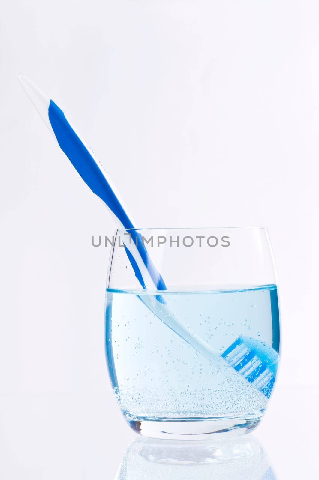 Toothbrush in a glass of water with mouthwash
