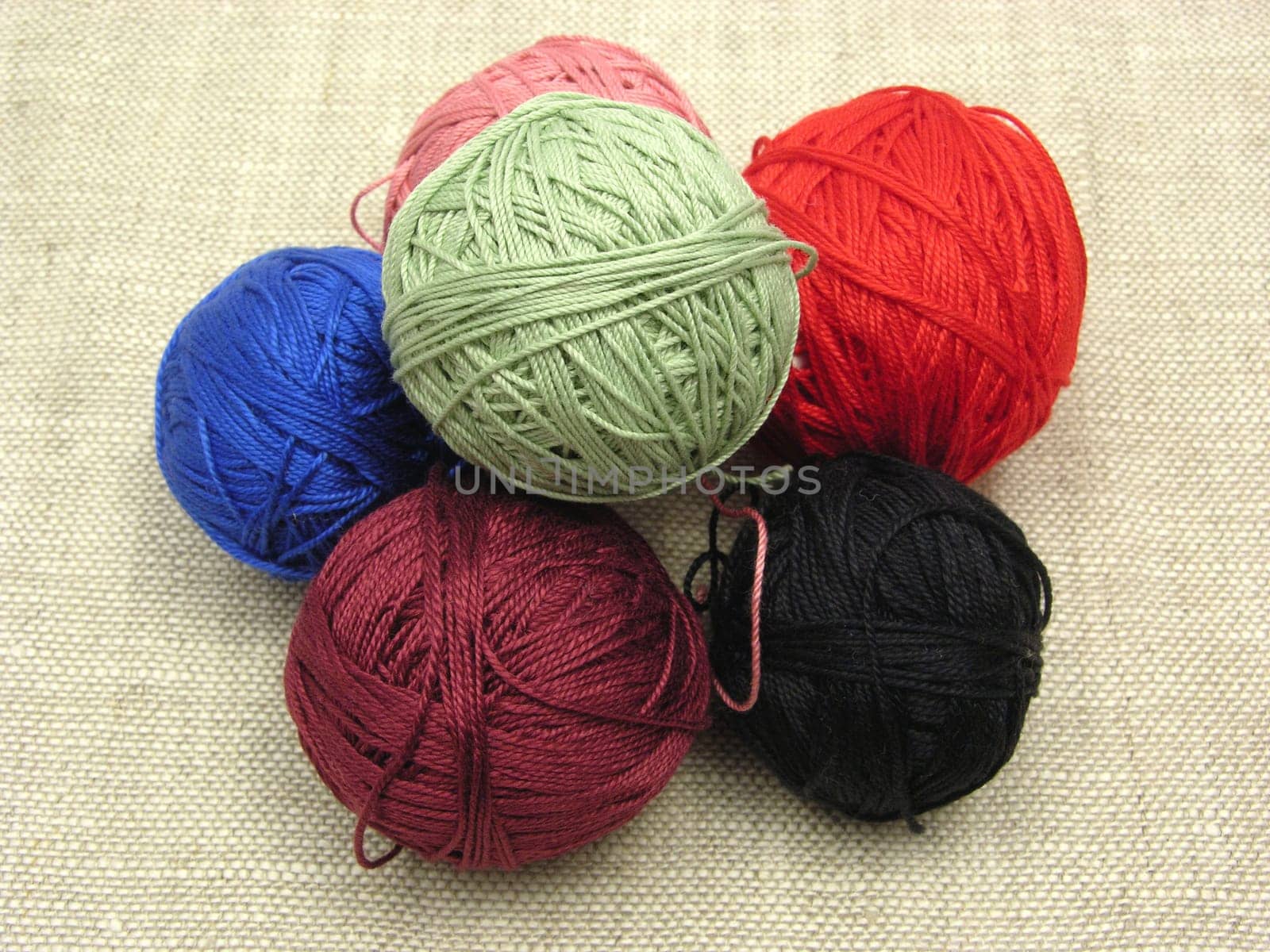Balls of wool stacked on a beige background