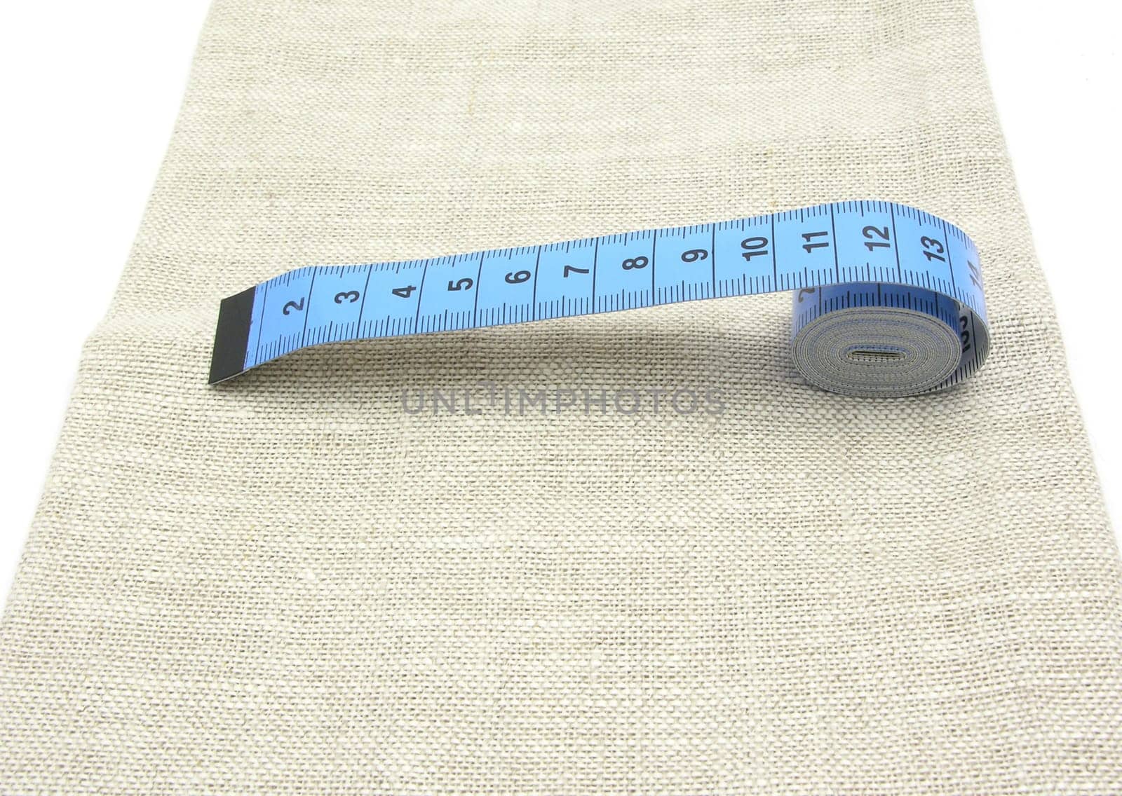 Blue Unrolled Tape Measure on Linen Fabric