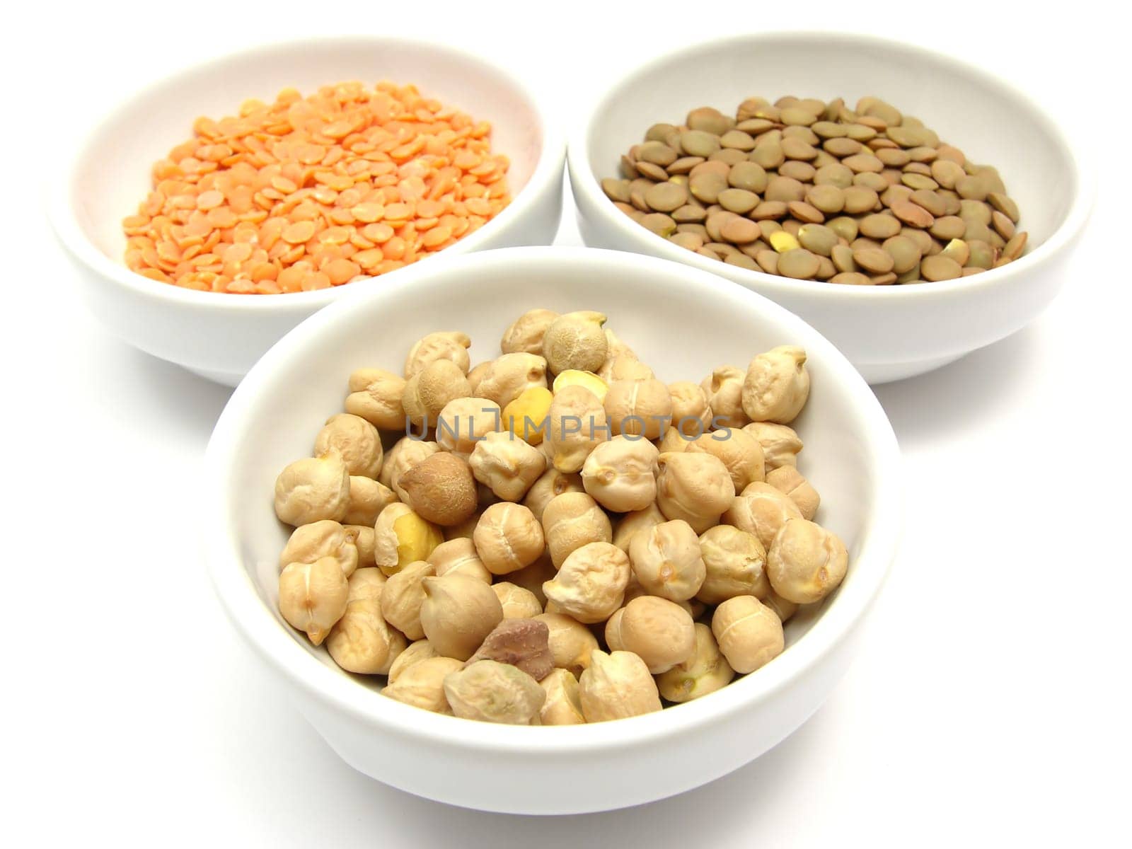 Three porcelain bowls with chickpeas,red and plate lentils
