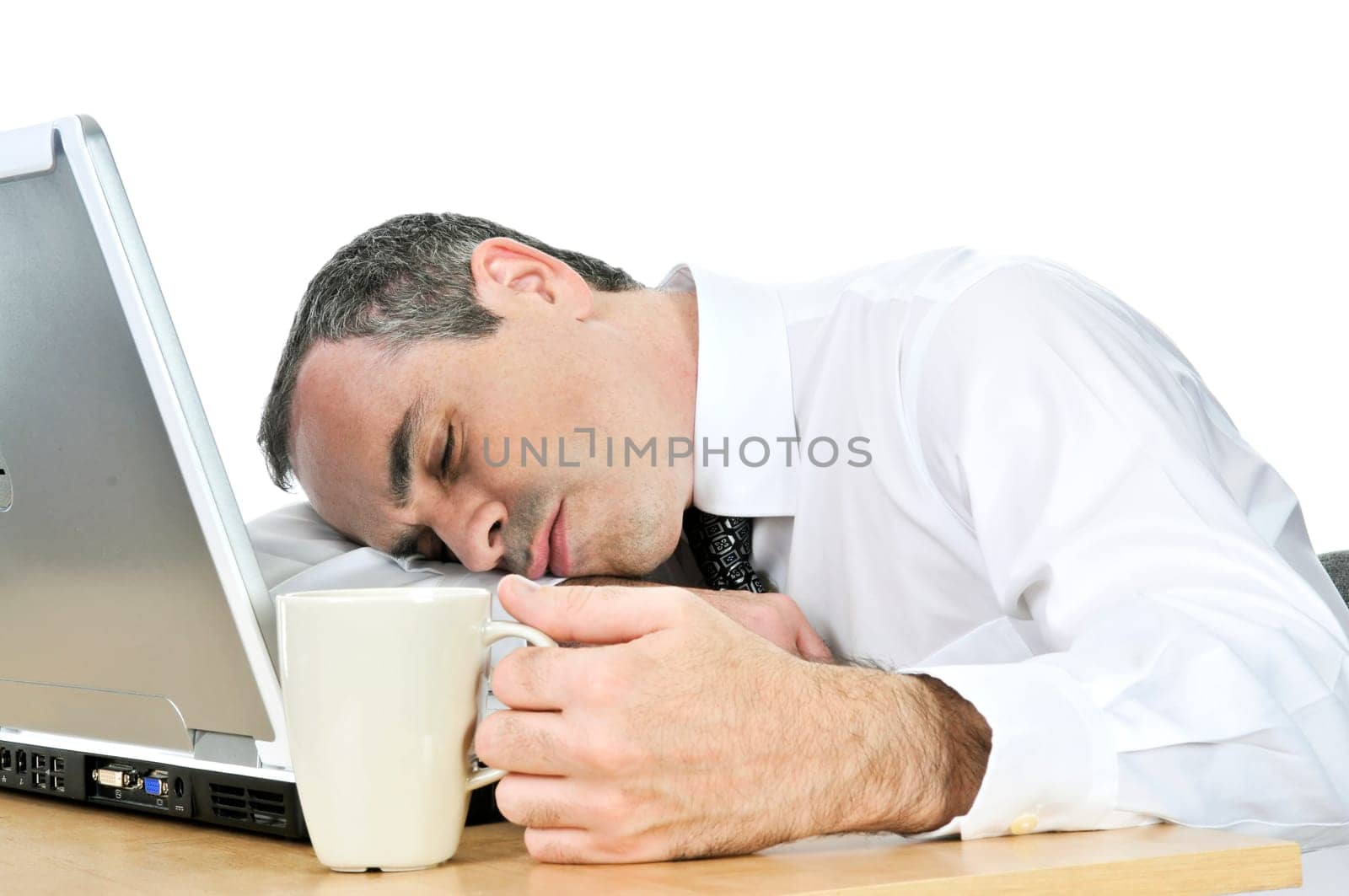 Businessman asleep at his desk on white background