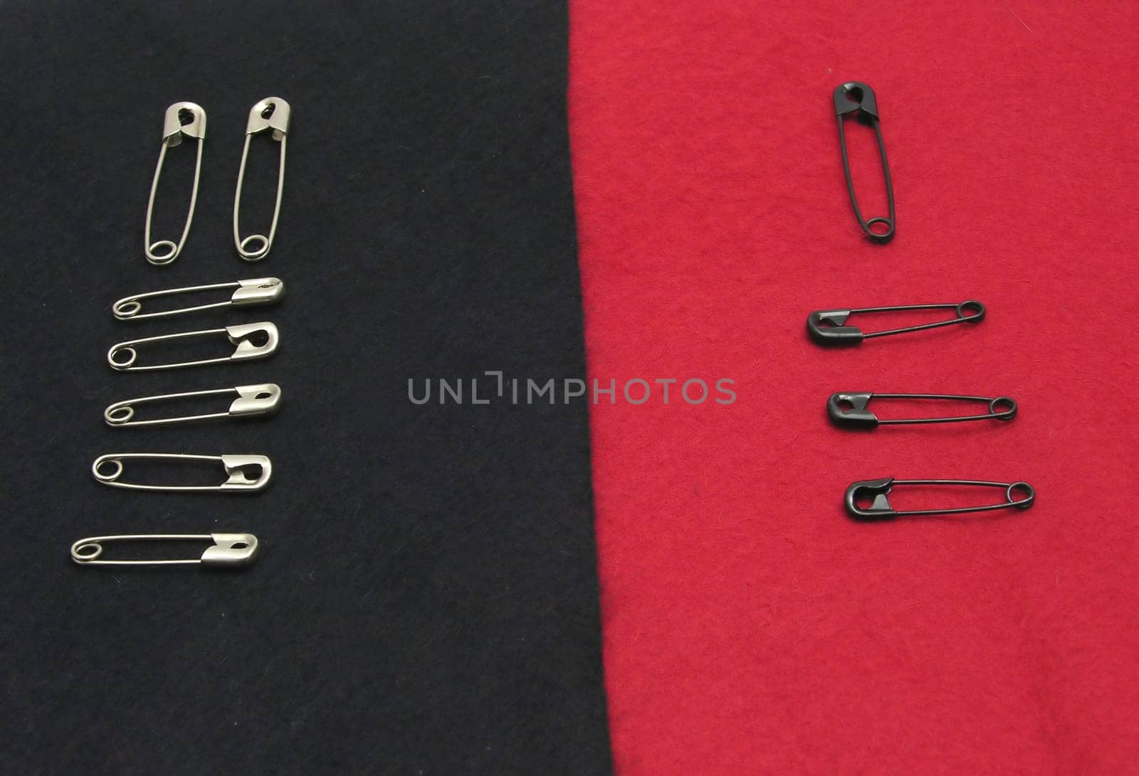Safety pins on black and red felt