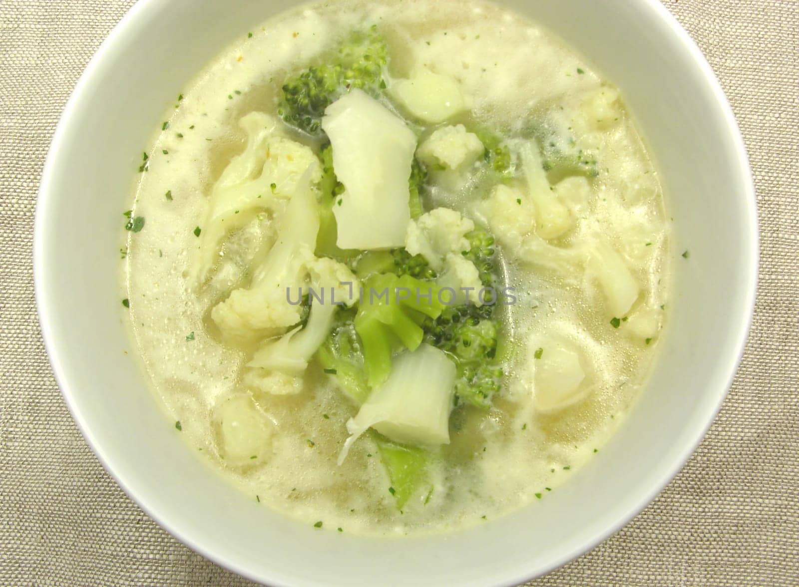 Soup with cauliflower and broccoli in porcelain bowl