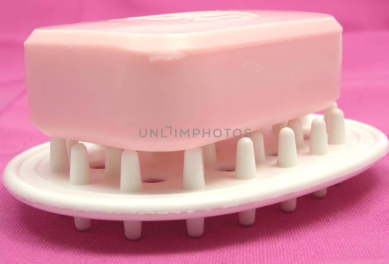 Purple soap with decorative items against gray background