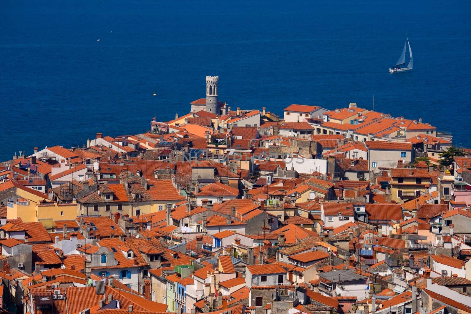 Roofs of a typical southern European town and a sailboat