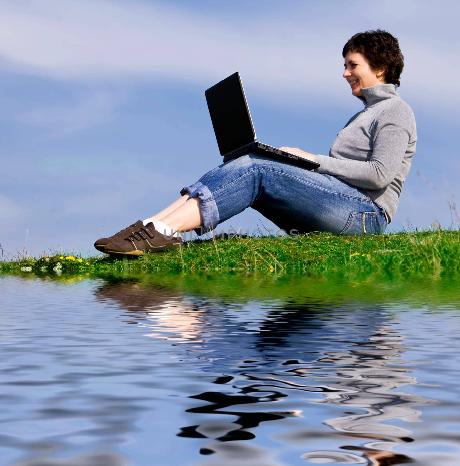 Young casual woman working on laptop out
