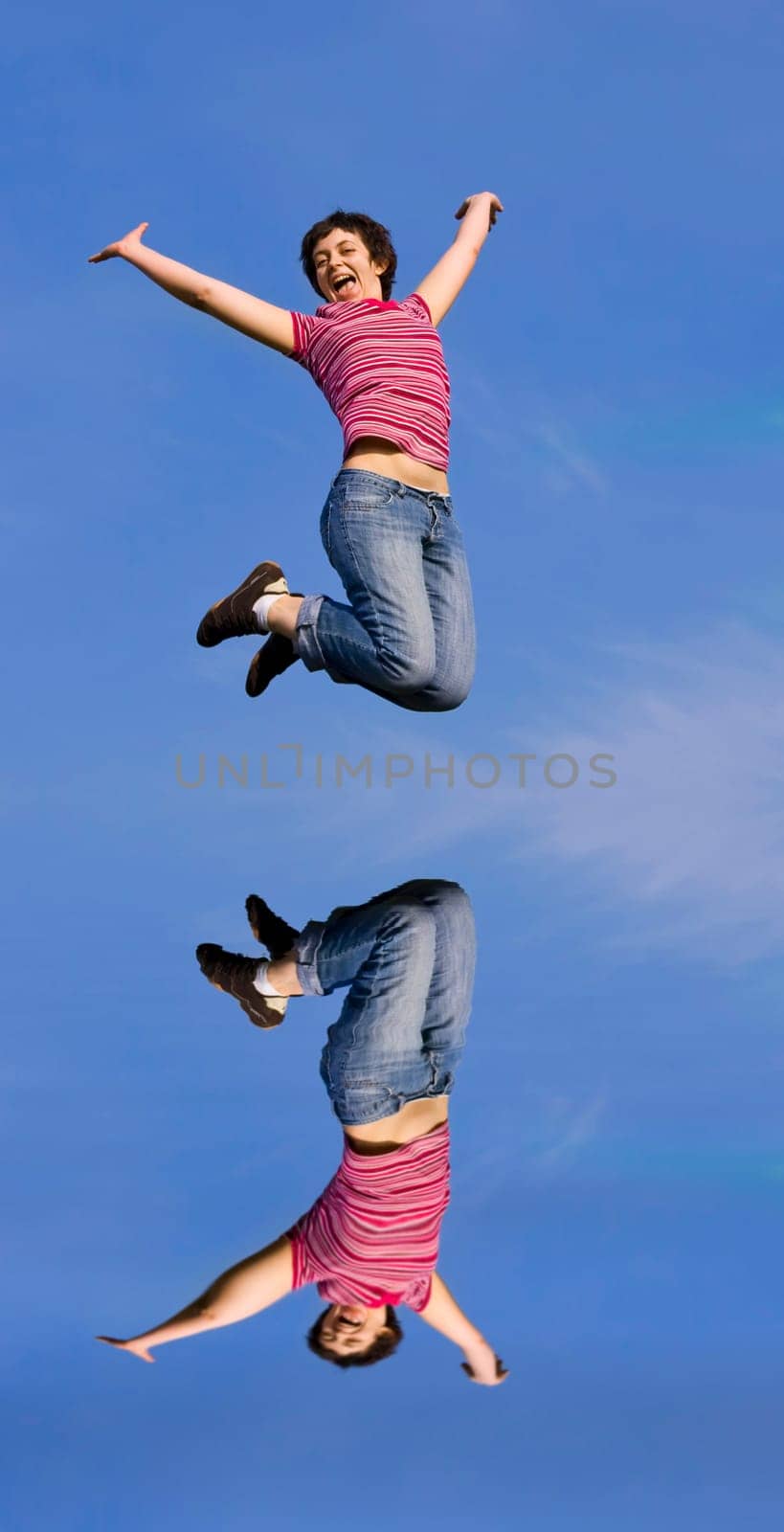 Young happy woman jumping high against b