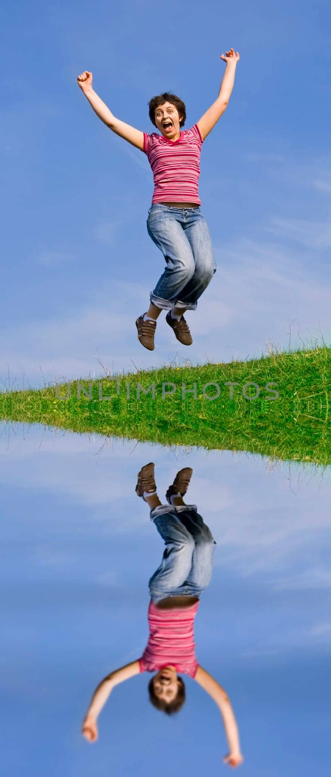 Young happy woman jumping high against b
