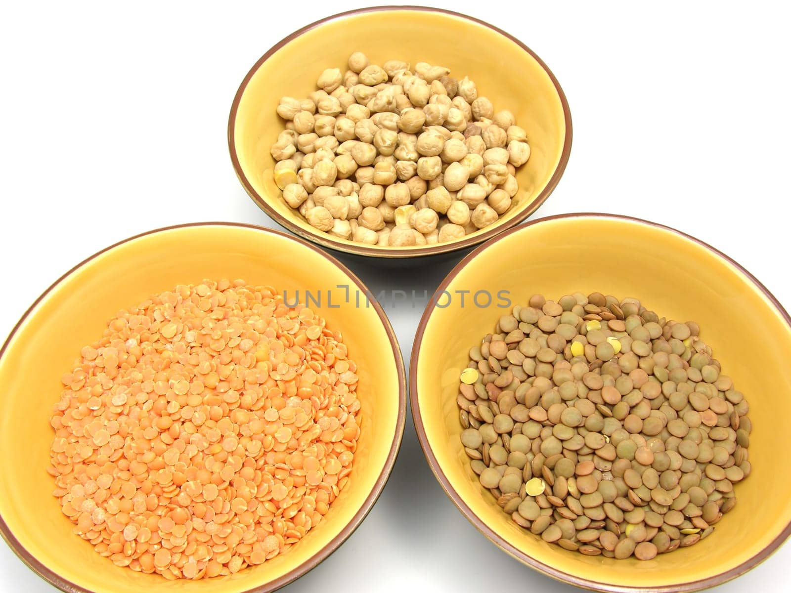 Three ceramic bowls with chickpeas,red and plate lentils