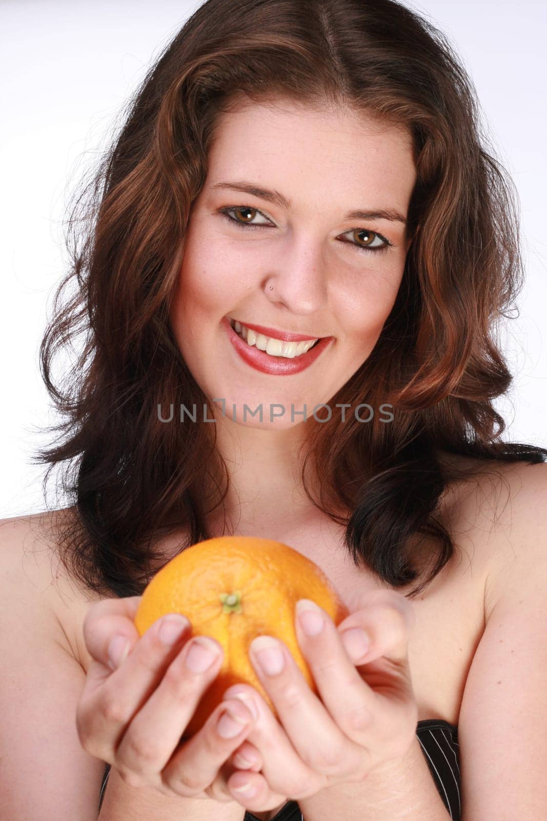 Young woman holding orange in hands