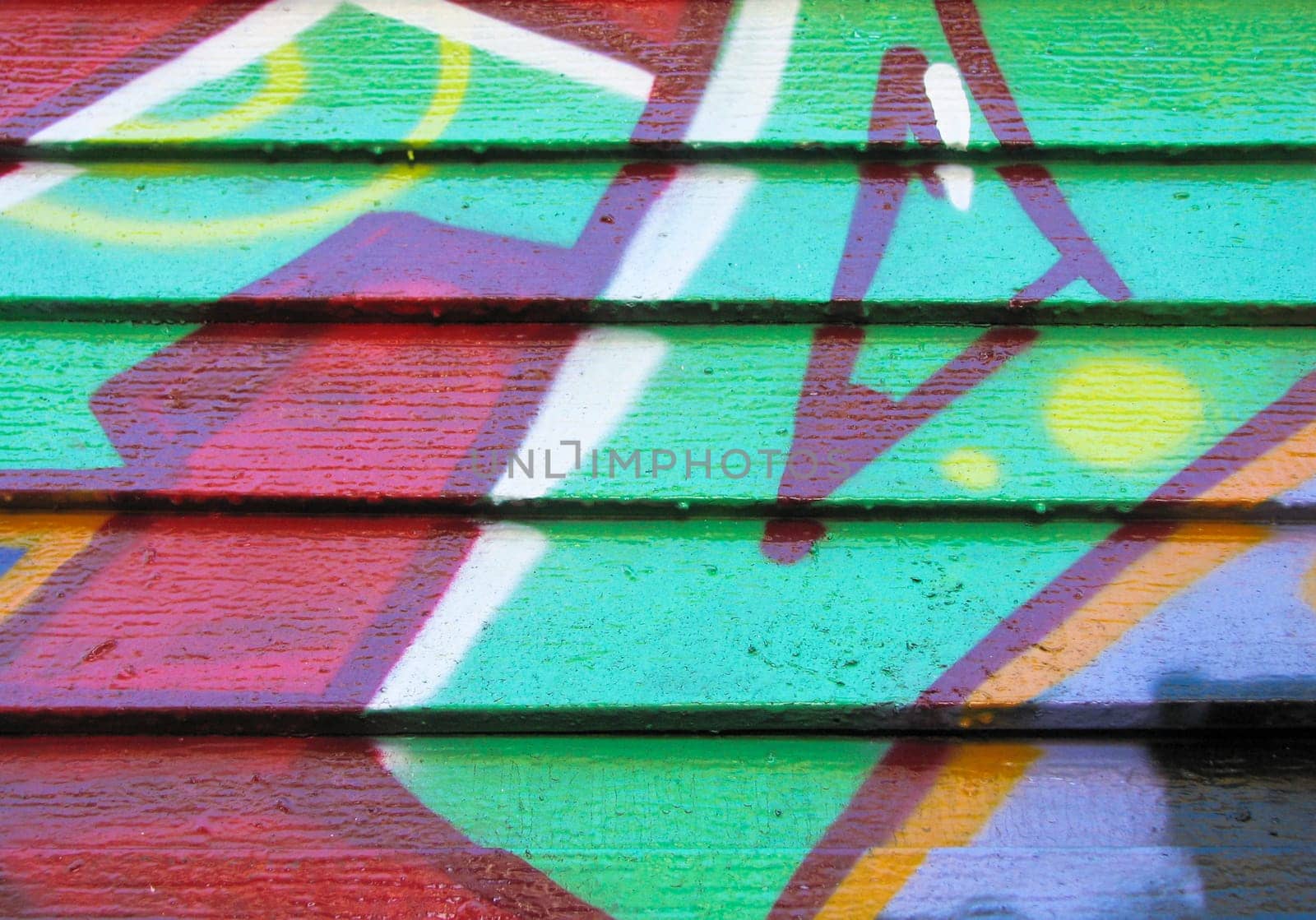Red and green graffiti on wood wall