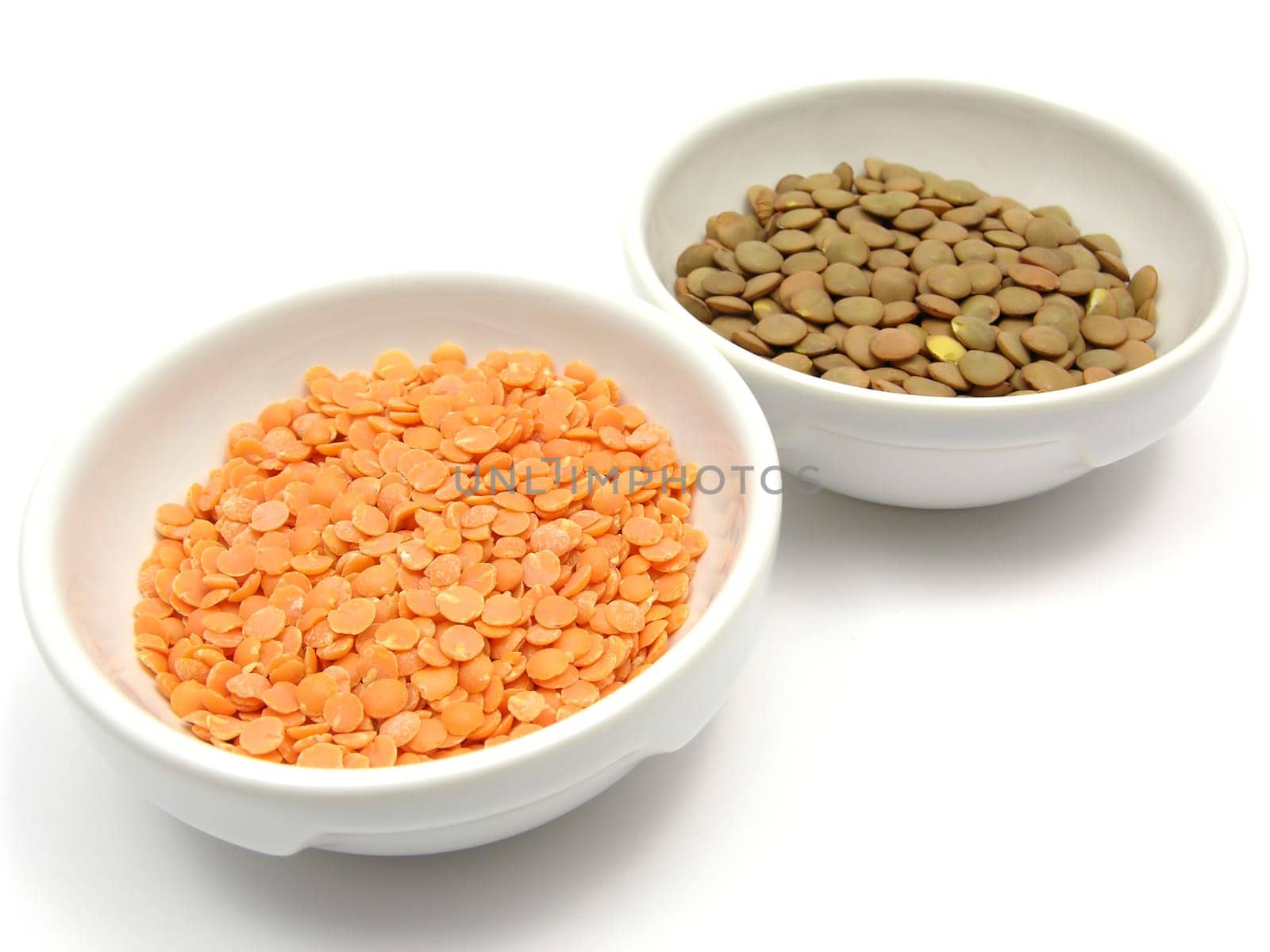 Two porcelain bowls with red lentils and plate lentils