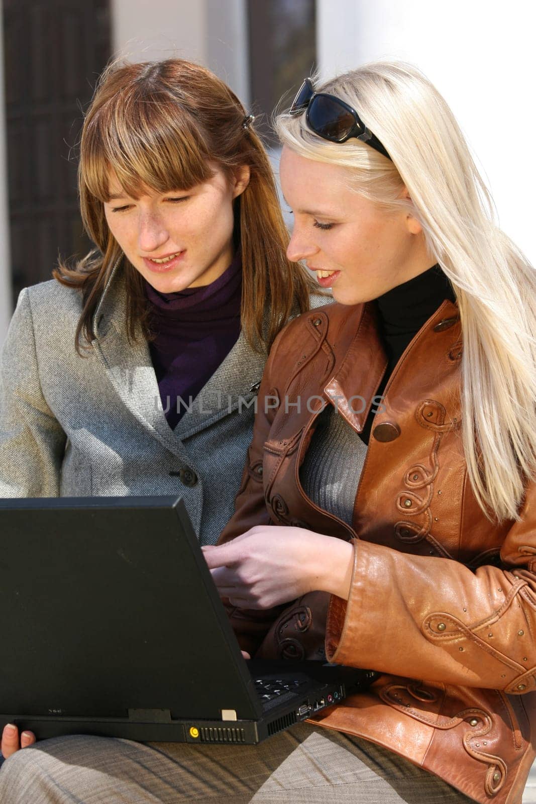 women working with laptop in city park