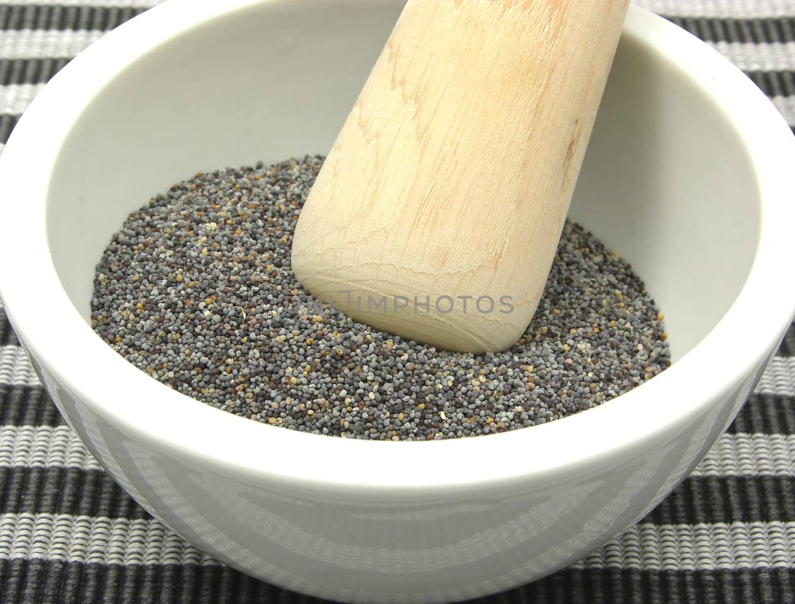 Poppy seeds in porcelain bowl with mortar