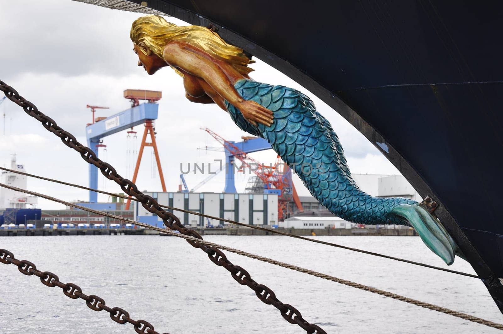a figurehead of a ship against the backdrop of the port of Kiel