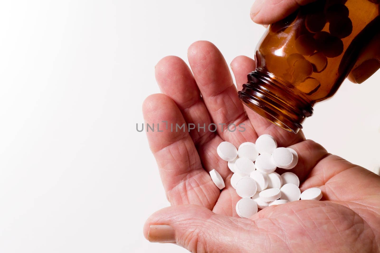 Senior hands pouring out tablets