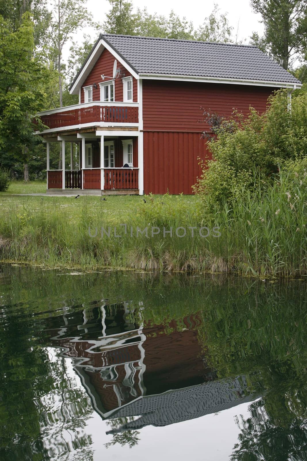 red wooden house by the lake
