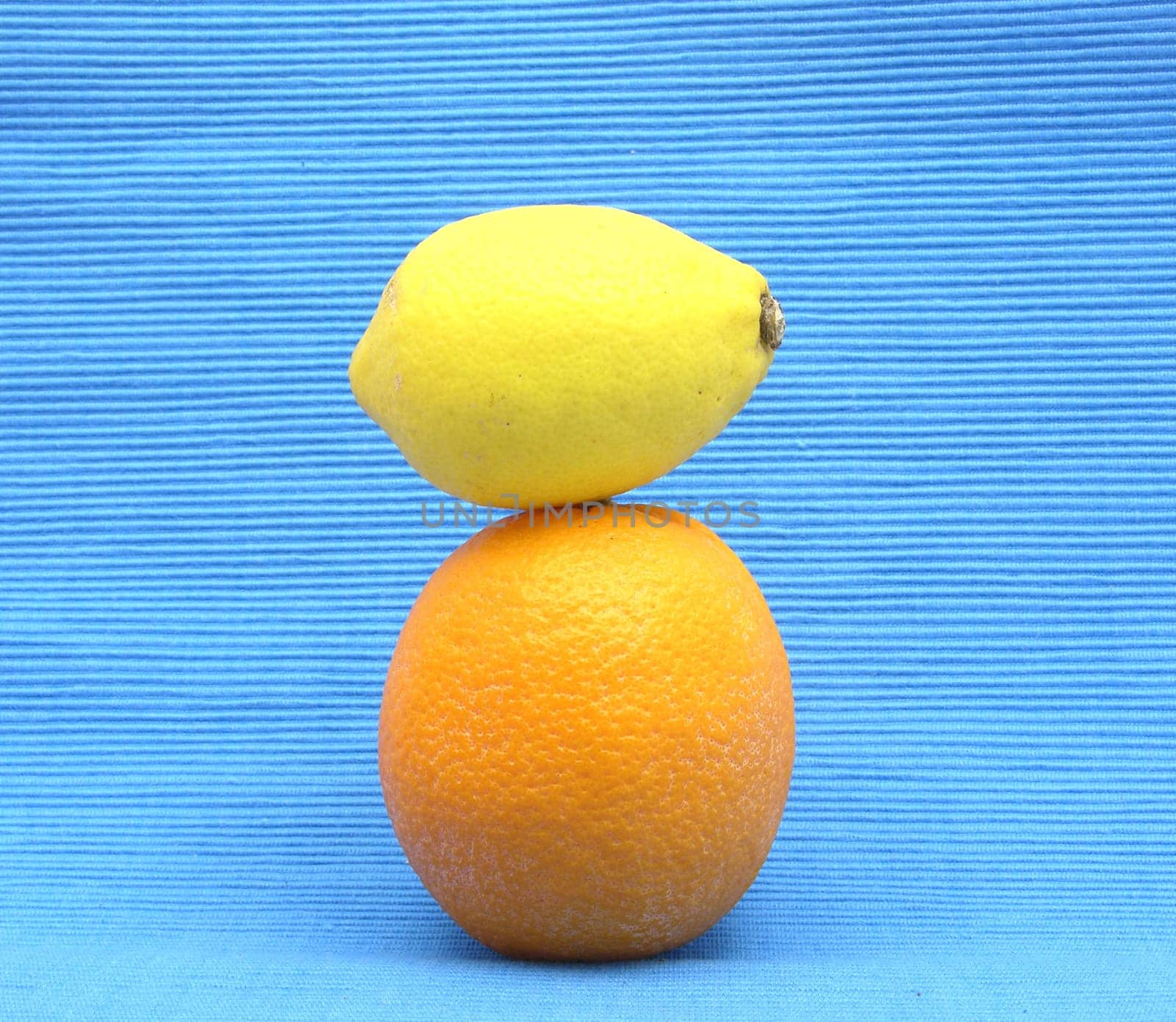 Lemon on orange stacked on blue background