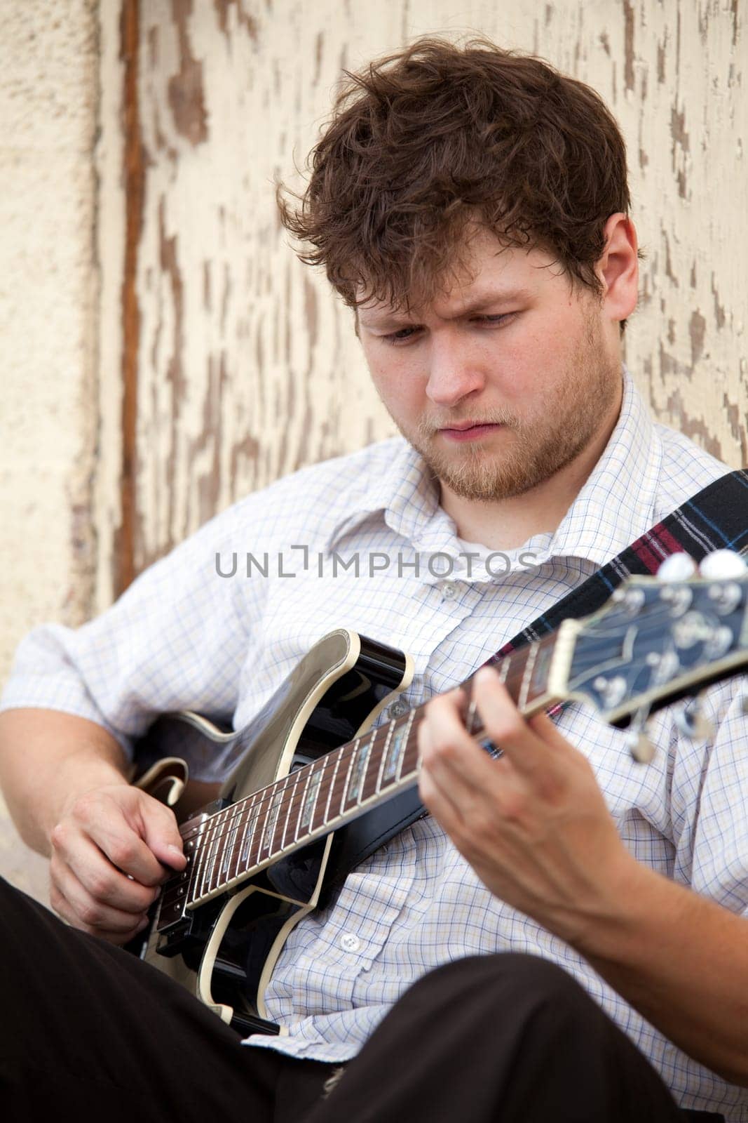 young man playing guitar outdoors
