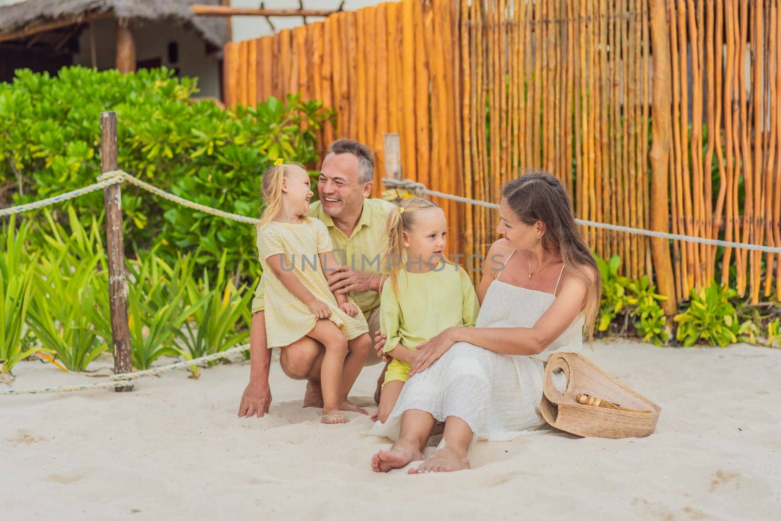 A joyful family, two girls, dad, and a pregnant mom, bask in tropical beach bliss, celebrating a radiant pregnancy amidst paradise by galitskaya