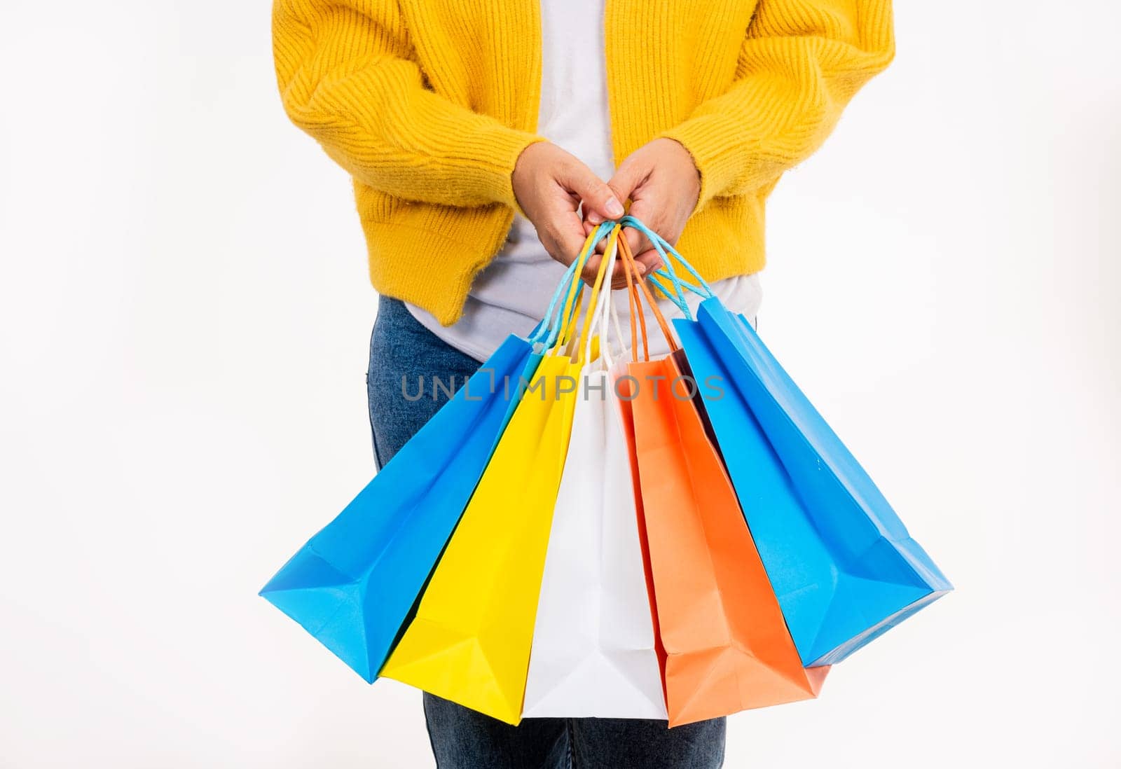 woman hand she wears yellow shirt holding shopping bags multicolor by Sorapop