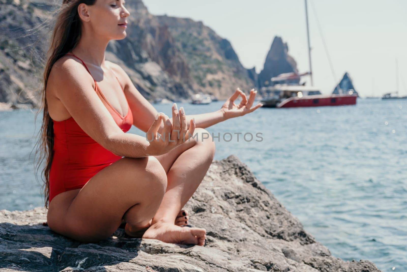 Woman sea yoga. Happy women meditating in yoga pose on the beach, ocean and rock mountains. Motivation and inspirational fit and exercising. Healthy lifestyle outdoors in nature, fitness concept. by panophotograph