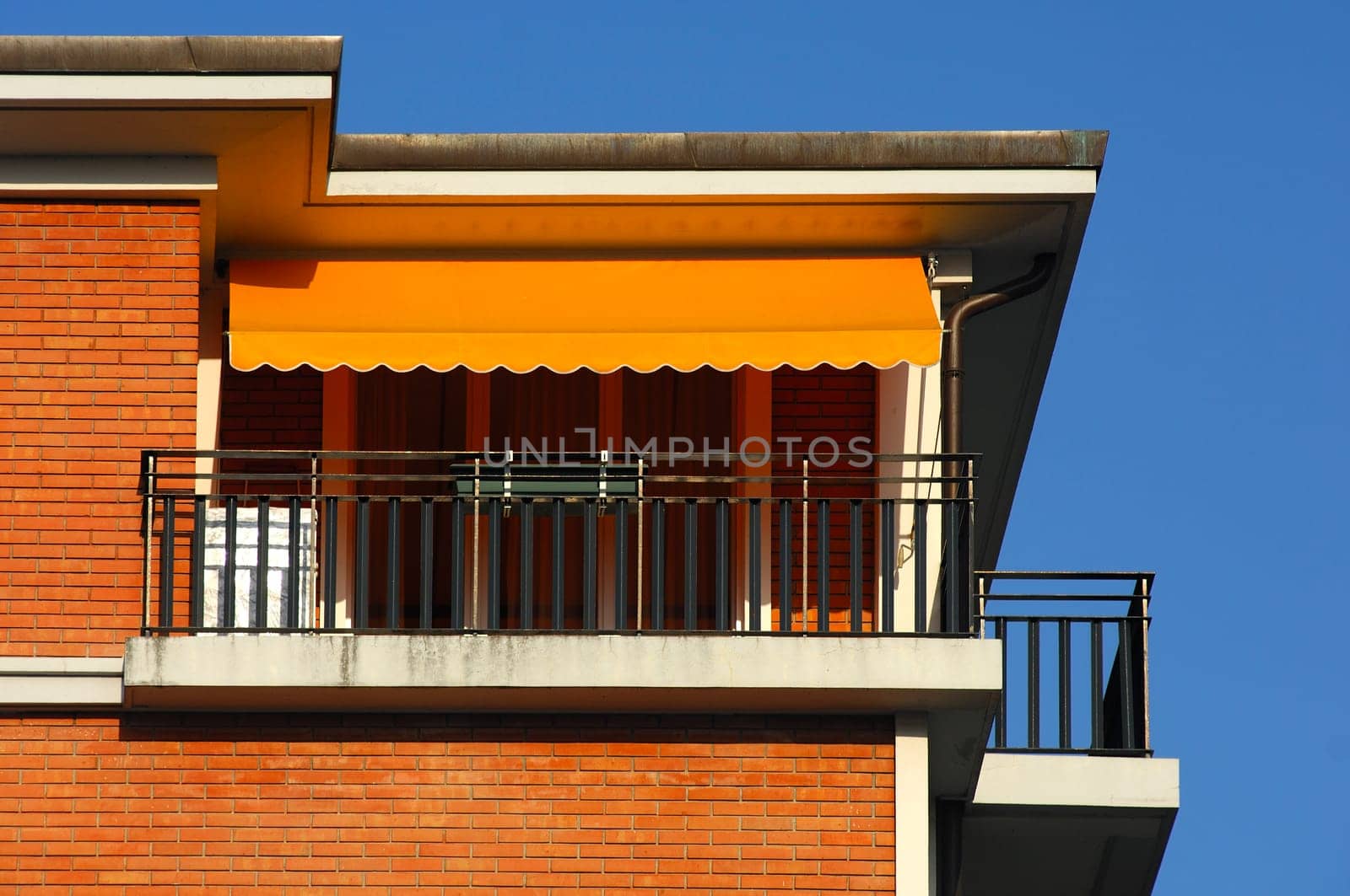 Attic apartment with balcony and orange awning