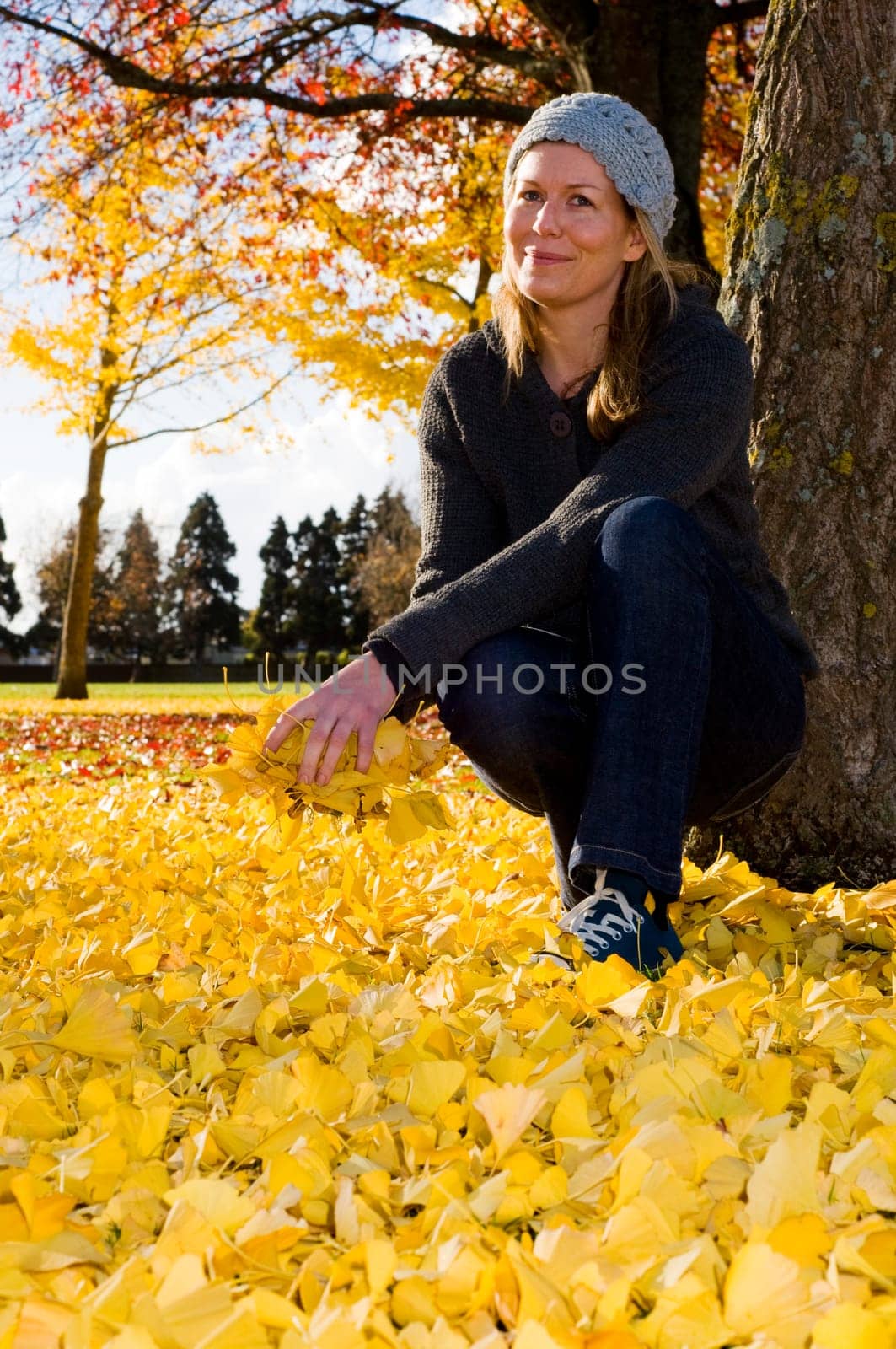 Women throwing yellow autumn leaves