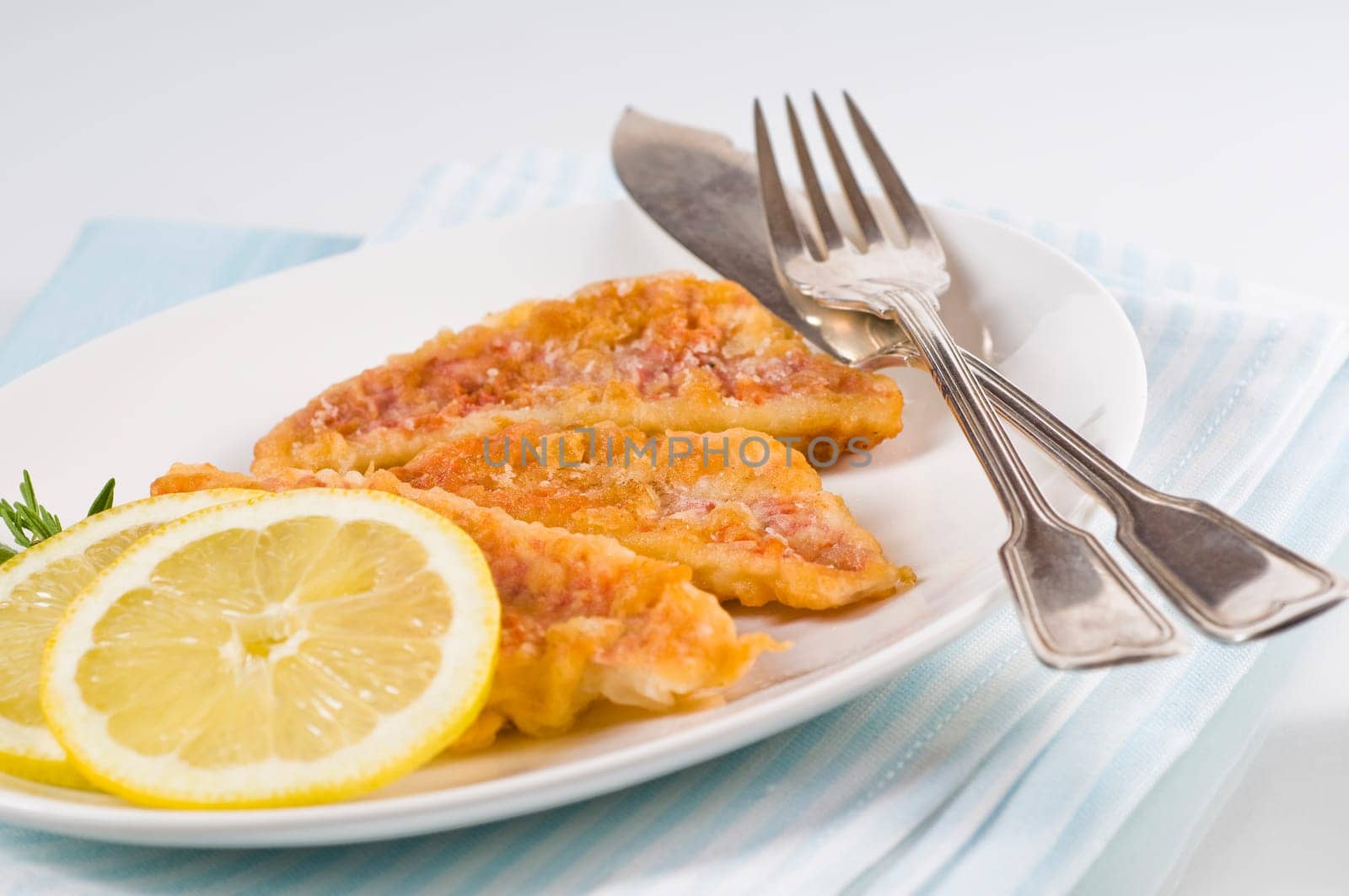 breaded fried mullet fillets on white plate
