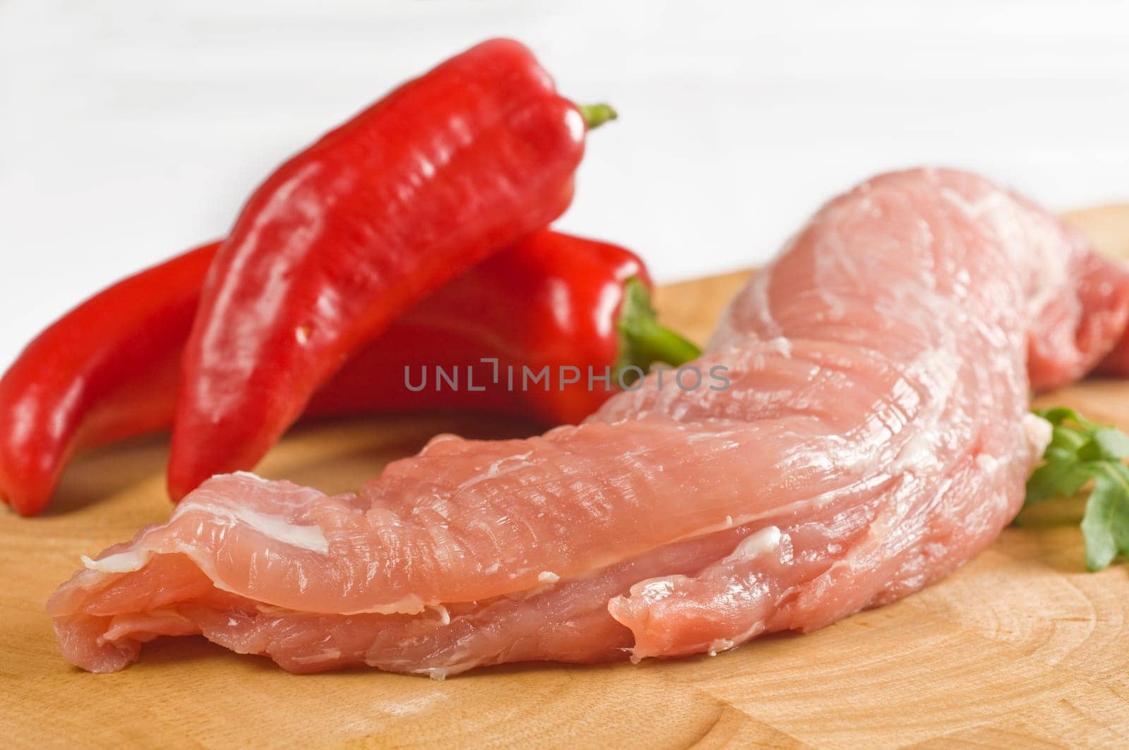 Raw pork tenderloin on wooden board