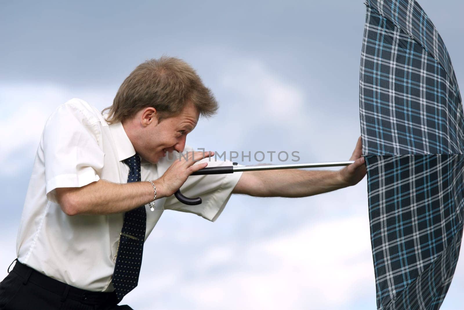 pushing umbrella against wind
