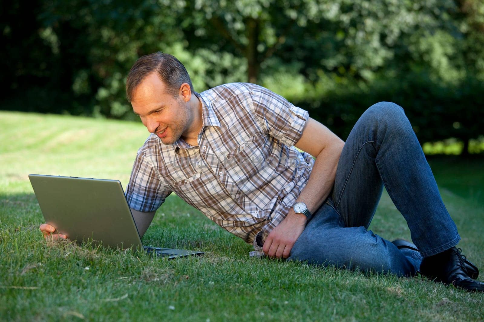 man with laptop on the grass