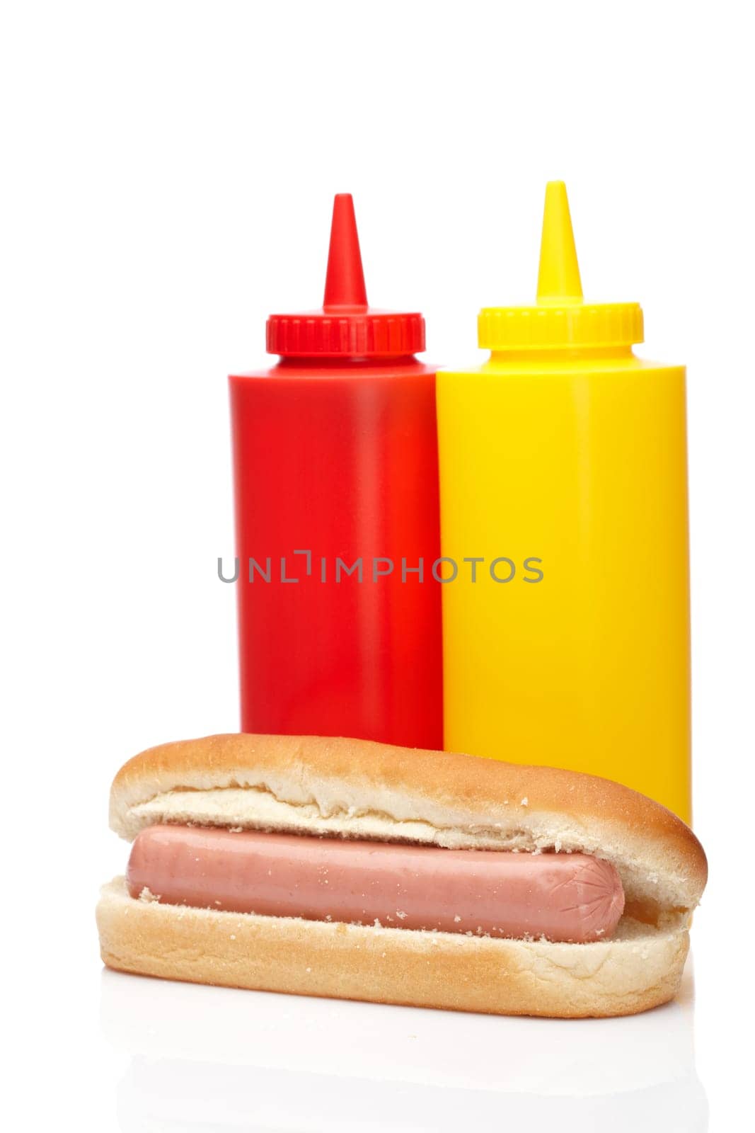 Hot dog with ketchup and mustard bottles