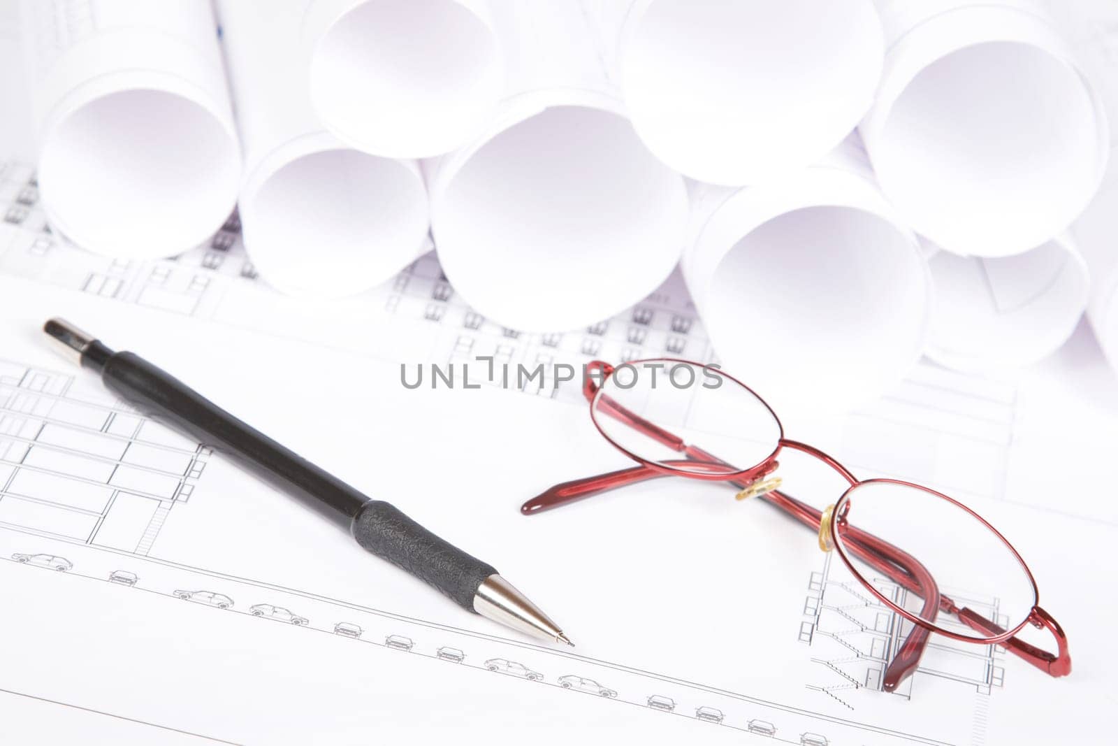 Blueprints, glasses and pencil